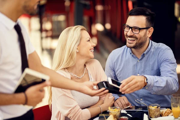 Happy Couple Paying Bill Lunch Bar Man Using Smart Phone — Foto de Stock