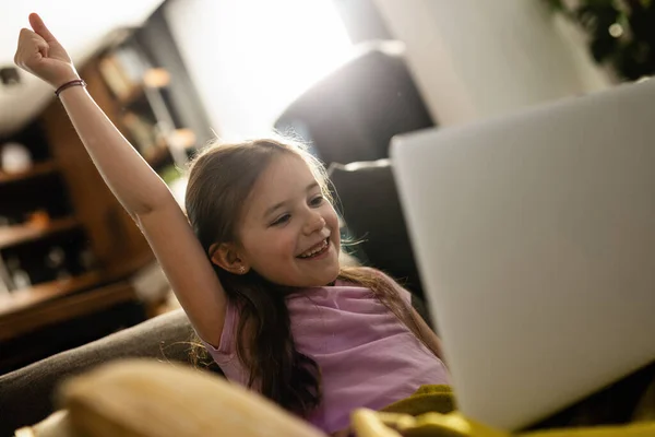Happy Little Girl Celebrating While Using Laptop Home — Stockfoto