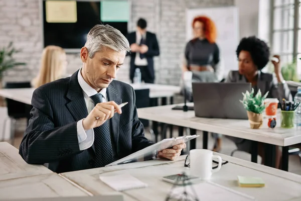 Serious Businessman Sitting Office Reading Business Reports People Background — Fotografia de Stock