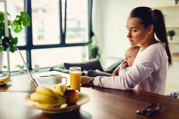 Displeased mother with a baby thinking of something while experiencing postnatal depression.