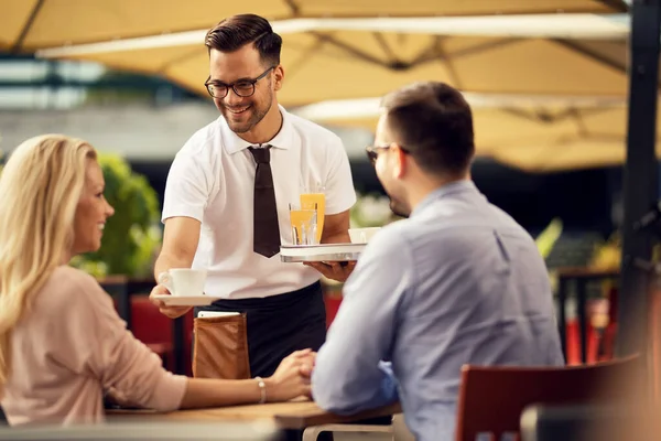 Young Smiling Waiter Brining Coffee Couple Outdoor Cafe — Stockfoto