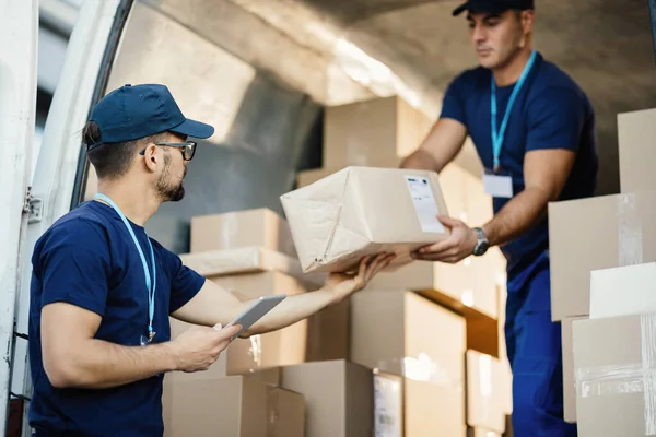 Young Courier Using Touchpad While Loading Packages His Coworker Delivery — Stock Fotó