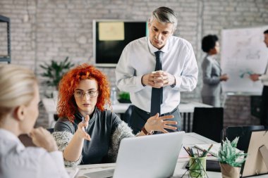 Business team having a meeting in the office and talking about upcoming projects. 