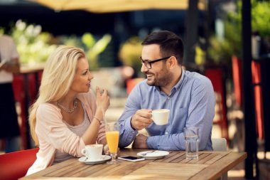Smiling couple drinking coffee and enjoying in conversation in a cafe.
