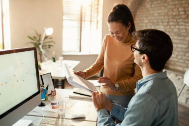 Ofiste raporları incelerken iş birliği yapan mutlu meslektaşlar. Kadınlara odaklan.. 