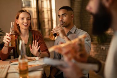 Bir grup genç girişimci ofiste pizza yerken bira içip sohbet ediyorlar.. 