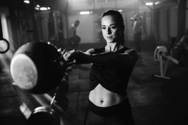 Black and white photo exercising with kettle bell on sports training in health club. 