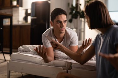 Young man having a conflict with his girlfriend who caught him cheating on her on the phone.