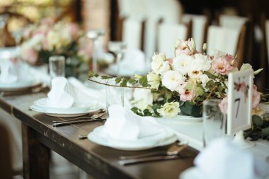 Dining table with floral centerpiece at wedding reception.
