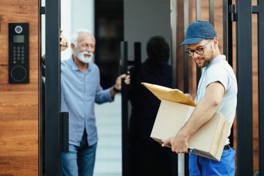 Young courier delivering packages to customer's home. 