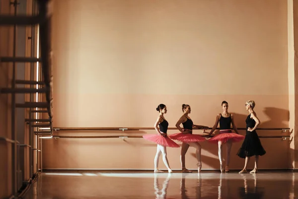 Ballet teacher communicating with teenage ballet dancers during a class at ballet school. Copy space.