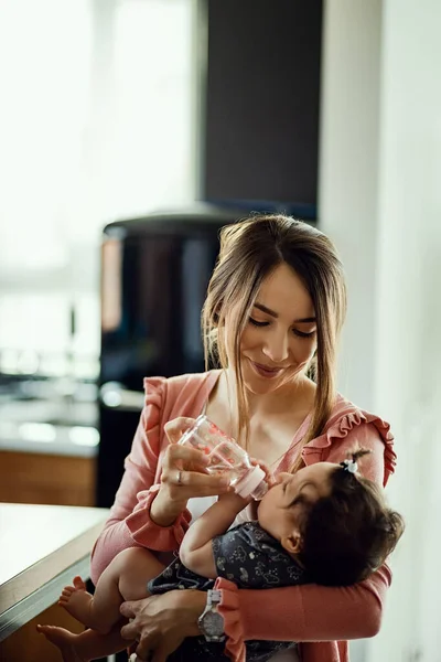 Young Caring Mother Feeding Her Baby Daughter Home — Stok fotoğraf