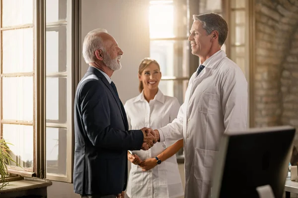 Happy Doctor Shaking Hands Senior Businessman While Nurse Standing Background — Fotografia de Stock