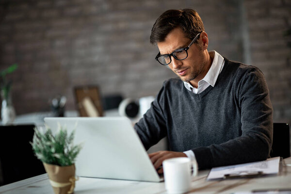 Businessman typing while using laptop and working in the office. 