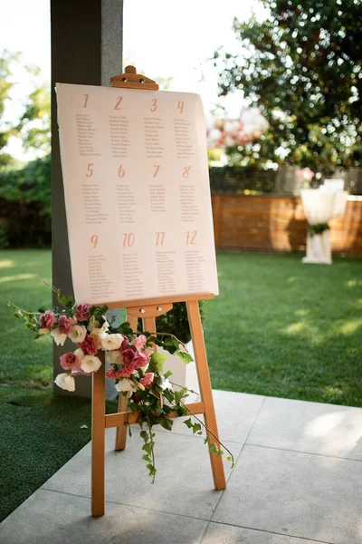 Welcome board at outdoor wedding venue.