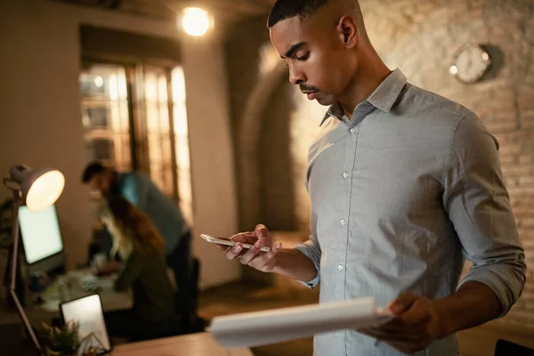 African American Entrepreneur Reading Message Smart Phone While Working Business — стоковое фото