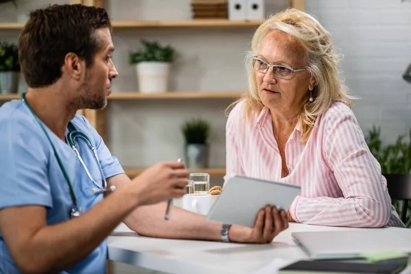 Senior Woman Communicating Doctor Who Using Digital Tablet Explaining Her — Foto de Stock