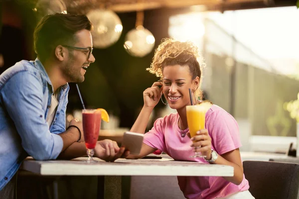 Happy Woman Her Boyfriend Using Mobile Phone While Drinking Cocktails — Stockfoto