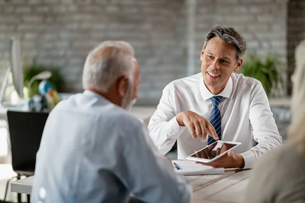 Happy Bank Manager Using Touchpad While Talking Senior Clients Meeting — Fotografia de Stock