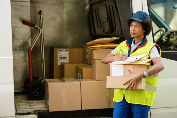 Female African American Courier Getting Ready Delivery Checking Package List — Stockfoto