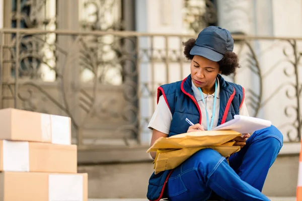 African American Postal Worker Getting Ready Package Delivery Filling Paperwork — Zdjęcie stockowe