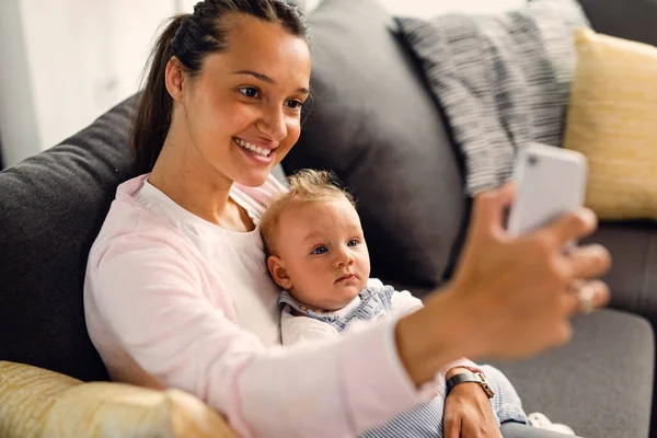Young Happy Mother Using Mobile Phone Taking Selfie Her Baby — Stockfoto