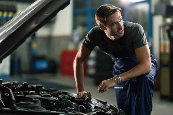 Young Auto Mechanic Looking Away While Repairing Car Engine Auto — Fotografia de Stock