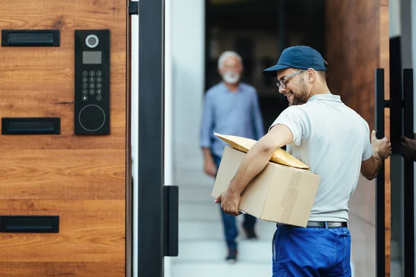 Young Happy Courier Making Home Delivery His Customer Standing Background — Stok Foto