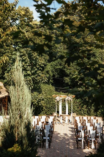 Decorated wedding place with wedding aisle in a garden.