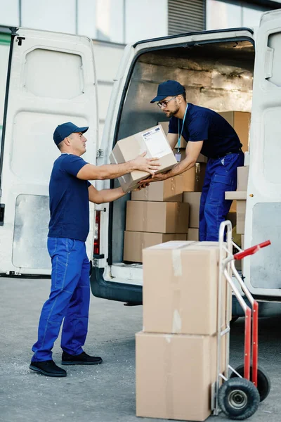 Male Workers Cooperating While Loading Cardboard Boxes Delivery Van — Foto Stock