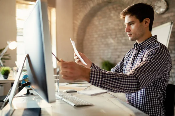 Young Entrepreneur Using Computer While Comparing Data Business Reports Office — Stock Fotó