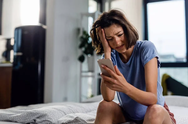 Unhappy Woman Crying While Sitting Bed Reading Text Message Her — Foto de Stock