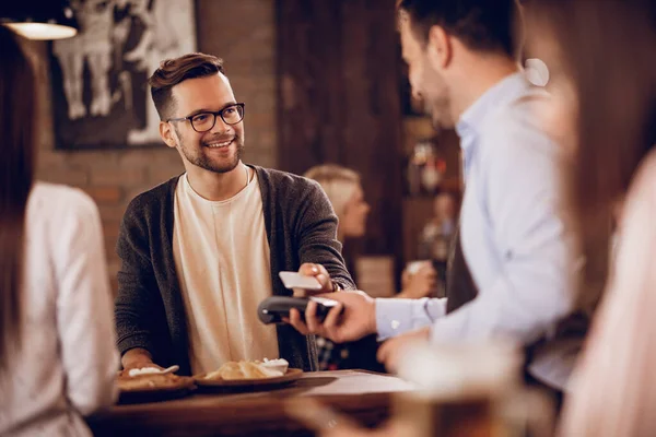 Happy Man Using Smart Phone While Making Contactless Payments Pub — Stockfoto