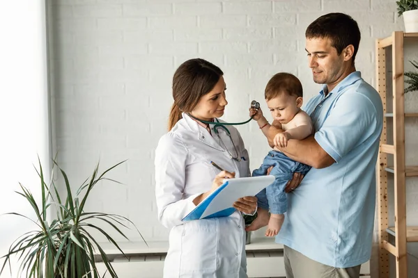 Mid Adult Father Holding His Small Son Communicating Female Doctor — Foto Stock