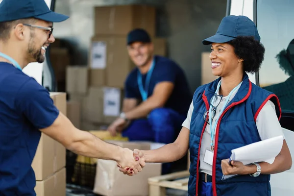 Happy African American Courier Handshaking Male Colleagues Front Delivery Van — Stockfoto