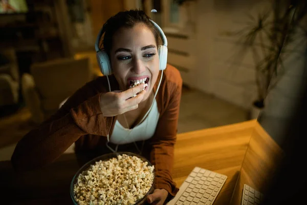 Young Woman Wearing Headphones While Eating Popcorn Watching Something Internet — Stockfoto
