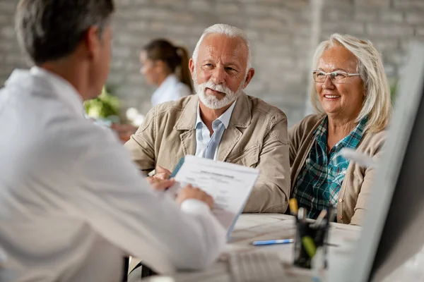 Happy Mature Couple Informing Themselves Health Insurance While Talking Doctor — Fotografia de Stock