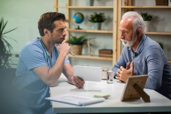 Concerned Doctor Talking His Mature Patient While Using Digital Tablet — Fotografia de Stock
