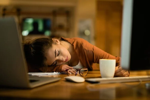 Young exhausted woman feel a sleep after studying at night at home.
