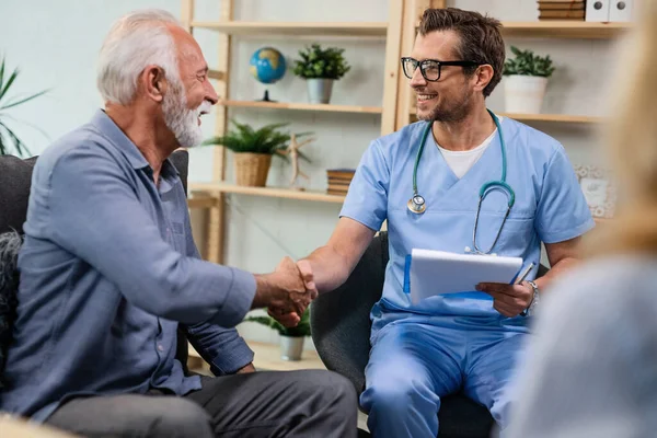 Happy General Practitioner Greeting Senior Man While Being Home Visit — Fotografia de Stock