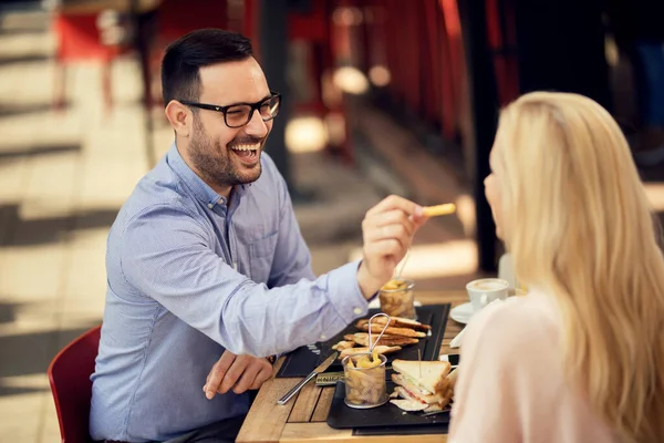 Happy Man Sharing French Fries Feeding His Girlfriend While Having — Stockfoto