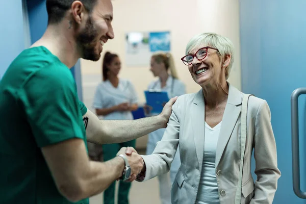 Happy Surgeon Senior Woman Handshaking While Greeting Lobby Clinic Focus — Foto de Stock
