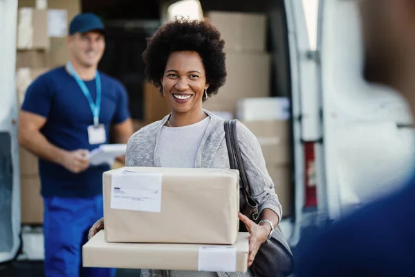 Happy African American Woman Holding Delivered Packages Couriers Standing Background — Stock Fotó