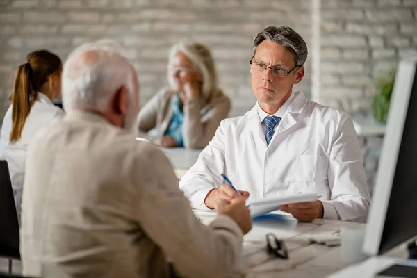 Mid Adult Doctor Listening His Senior Patient Talk Health Issues — Stockfoto