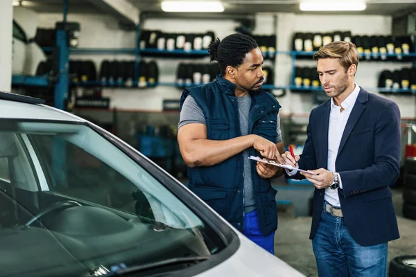 Young Black Auto Mechanic His Manager Communicating While Going Checklist — ストック写真