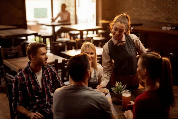 Happy Waitress Serving Peanuts Group Young People Who Drinking Beer — Stockfoto