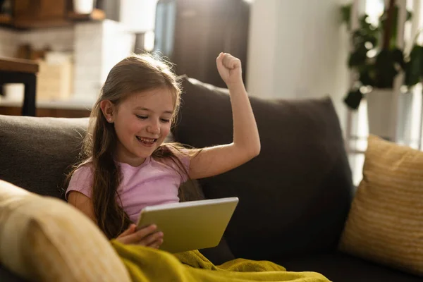 Happy Little Girl Celebrating While Playing Games Digital Tablet Living — Stockfoto