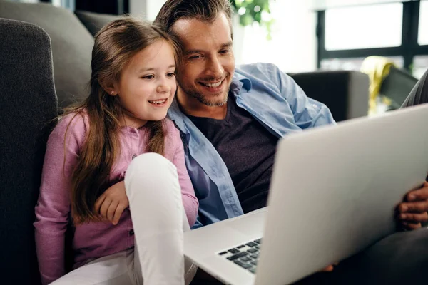Χαμογελώντας Κοριτσάκι Και Πατέρας Της Χρησιμοποιώντας Φορητό Υπολογιστή Ενώ Χαλαρώνοντας — Φωτογραφία Αρχείου