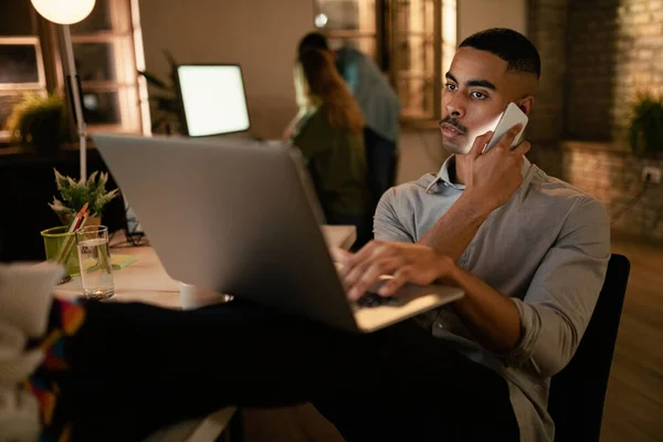 Afrikai Amerikai Vállalkozó Használja Laptop Beszél Mobiltelefon Miközben Késő Estig — Stock Fotó
