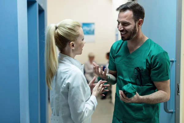 Happy Surgeon Talking Female Doctor While Standing Hallway Hospital — Foto de Stock